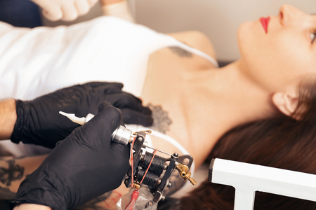 Professional artist making tattoo in salonの写真素材
