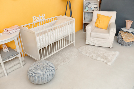 Children's room interior with crib and comfortable armchairの写真素材
