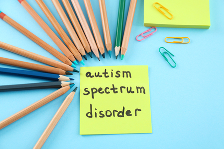 Note paper with text AUTISM SPECTRUM DISORDER on color backgroundの写真素材
