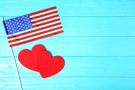 Red felt hearts and American flag on wooden background. USA holidayの写真素材