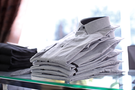 Classic men's shirts on shelf in boutiqueの写真素材