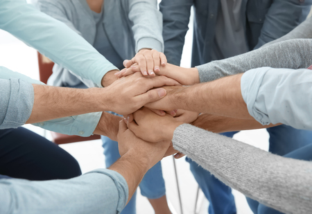 People putting hands together, closeup. Group therapy