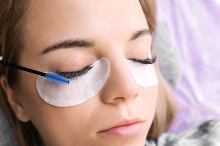 Young woman undergoing eyelash extensions procedure, closeupの写真素材