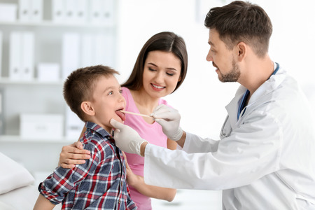 Children's doctor examining little boy in hospitalの写真素材