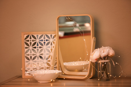 Beautiful modern mirror as decorative element on tableの写真素材
