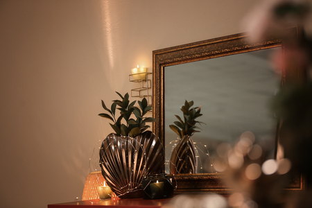 Vase with plant and beautiful mirror on tableの写真素材