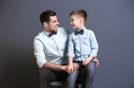 Stylish father and son on gray backgroundの写真素材