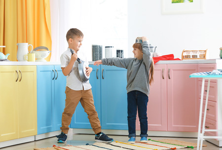Cute little children playing with kitchenware at homeの写真素材