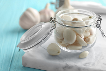 Jar with garlic cloves on boardの写真素材