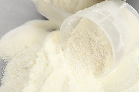 Protein powder and measuring scoop on table, closeupの写真素材