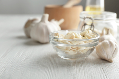 Bowl with chopped garlic on wooden tableの写真素材