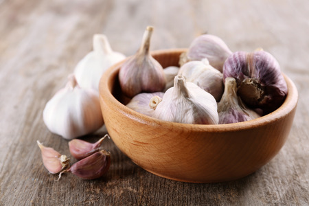 Bowl with fresh garlic on wooden tableの写真素材