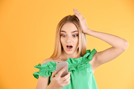 Young woman talking on cell phone against color backgroundの写真素材