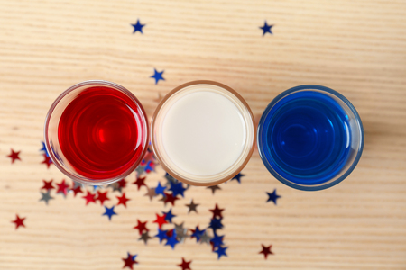 Cocktails in colors of American flag on wooden tableの写真素材