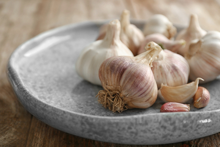 Plate with fresh garlic on tableの写真素材