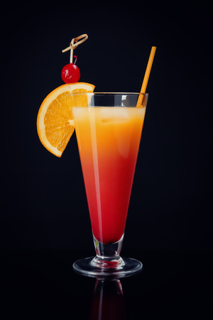 Glass of Sex on the Beach cocktail against black backgroundの写真素材