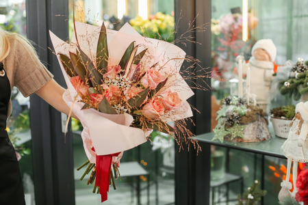 Female florist holding beautiful bouquet in flower shopの写真素材