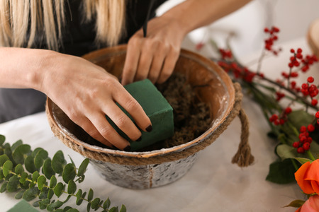 Female florist using sponge for work in flower shopの写真素材