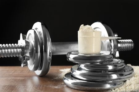 Measuring scoop with protein powder on  weight platesの写真素材