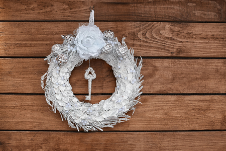 Beautiful Christmas wreath made by professional florist hanging on wooden backgroundの写真素材