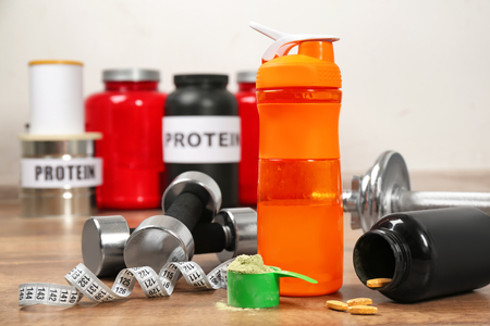 Composition with protein powder, dumbbells and pills on tableの写真素材
