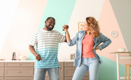 Cute interracial couple dancing at homeの写真素材