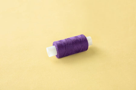 Purple sewing thread on light background