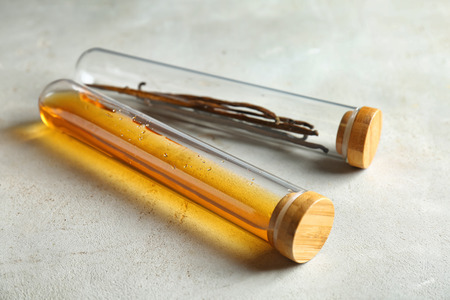 Vials with vanilla extract and sticks on table, closeupの写真素材