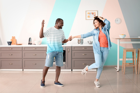 Cute interracial couple dancing at homeの写真素材