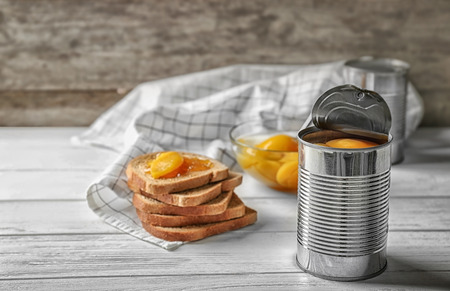 Can with pickled apricots on tableの写真素材