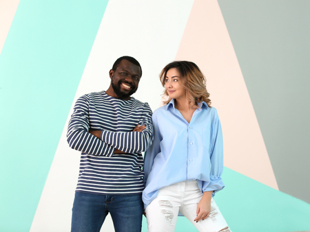 Cute interracial couple on color backgroundの写真素材