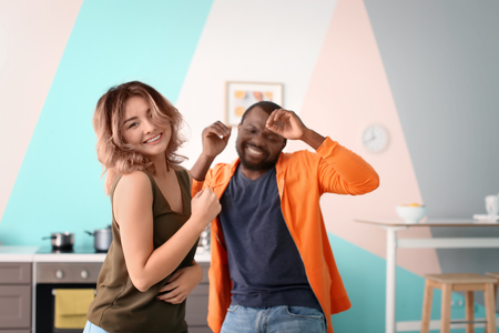 Cute interracial couple dancing at homeの写真素材