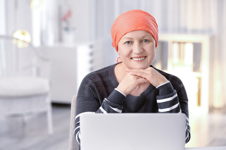 Mature woman ill with cancer in headscarf indoorsの写真素材