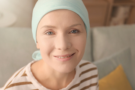 Young woman with cancer in headscarf indoorsの写真素材