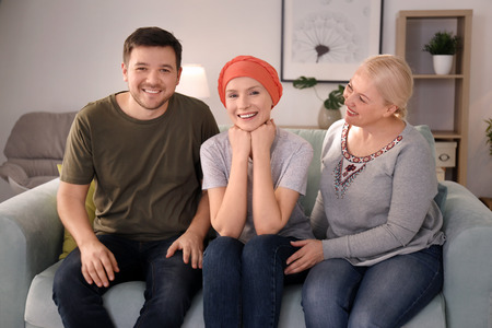 Family visiting young woman with cancer indoorsの写真素材