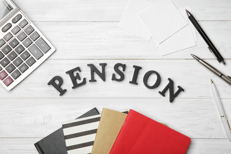 Word "Pension" and calculator on wooden backgroundの写真素材