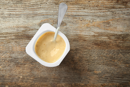 Plastic cup with yogurt on wooden backgroundの写真素材