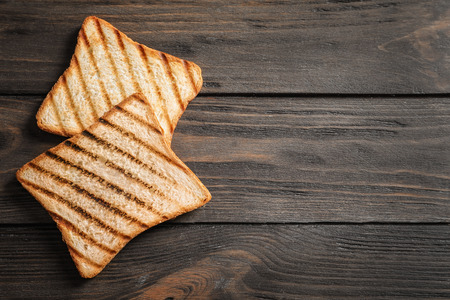 Tasty toasted bread on wooden table