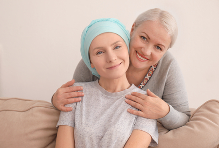 Mature woman visiting her daughter with cancer indoorsの写真素材