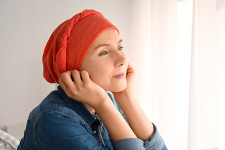 Young woman with cancer in headscarf indoorsの写真素材