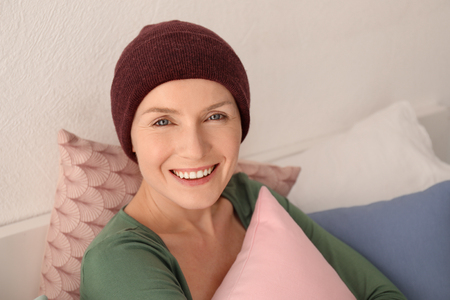 Young woman with cancer in hat indoorsの写真素材