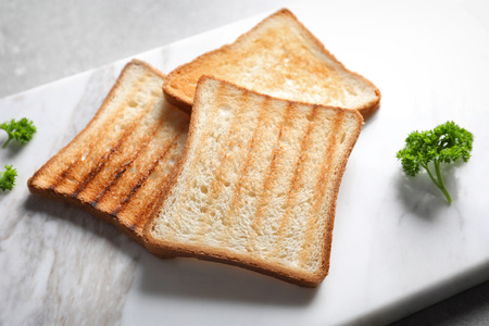 Tasty toasted bread on marble board