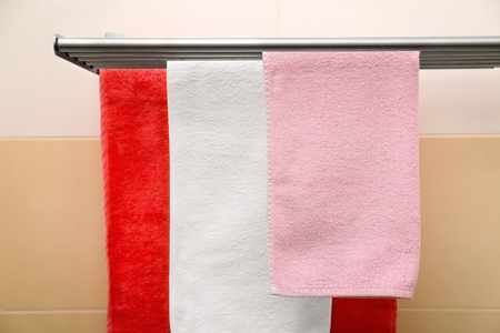 Soft towels hanging on rack indoorsの写真素材