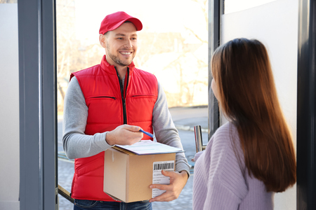 Woman and courier with parcel at doorway