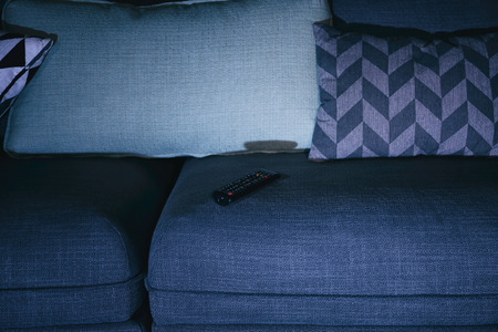 Remote control on comfortable couch, closeup. Home cinemaの写真素材