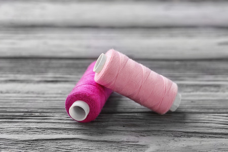 Colorful sewing threads on wooden background
