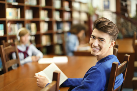 Student with book studying in libraryの写真素材