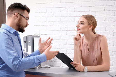 Male receptionist with trainee at workplaceの写真素材