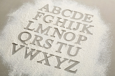 Silhouettes of alphabet letters on scattered flourの写真素材