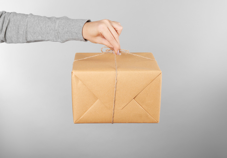 Woman holding parcel on color backgroundの写真素材